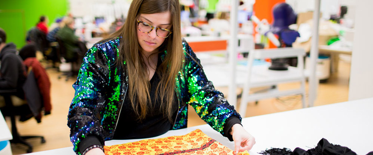 One of our designers reviewing fabric for a costume