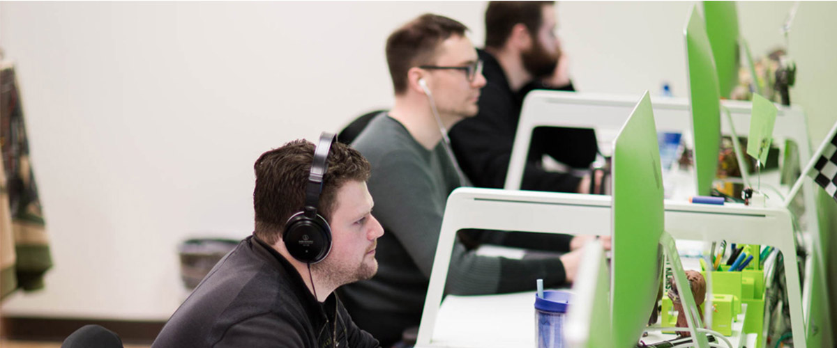 A group of people behind a computer hard at work